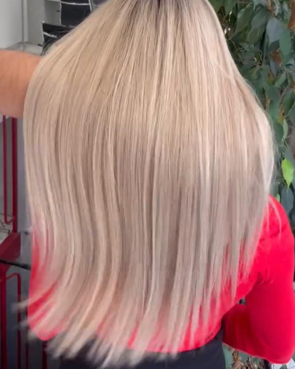 Résultat AirTouch au salon : blond polaire fondu sur cheveux longs lisses, vue de dos