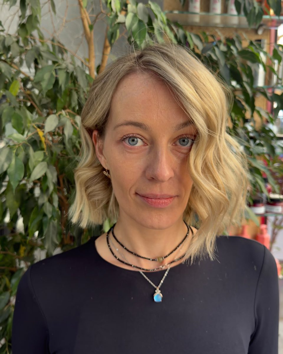 Cliente au salon avec un carré blond lumineux coiffé en ondulations souples, vue de face