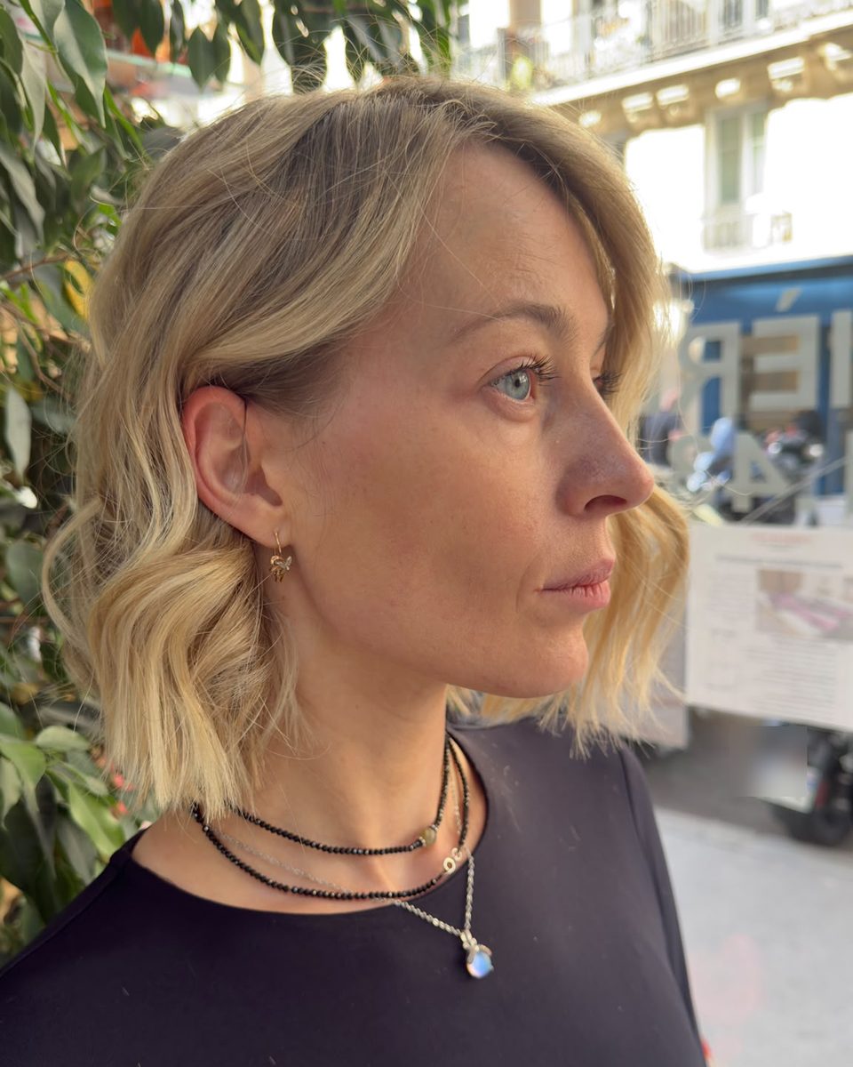 Profil d’un carré blond ondulé avec racine fondue, devant le salon