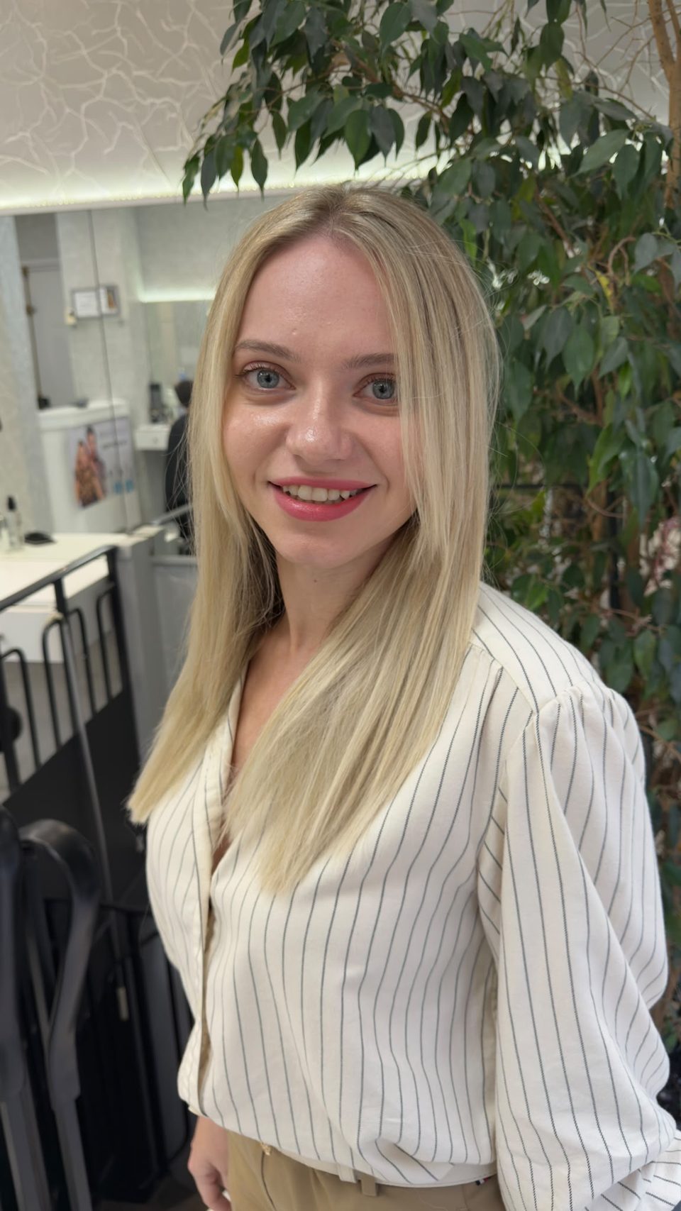 Cliente au salon avec un blond doré lisse, coupe dégradée autour du visage