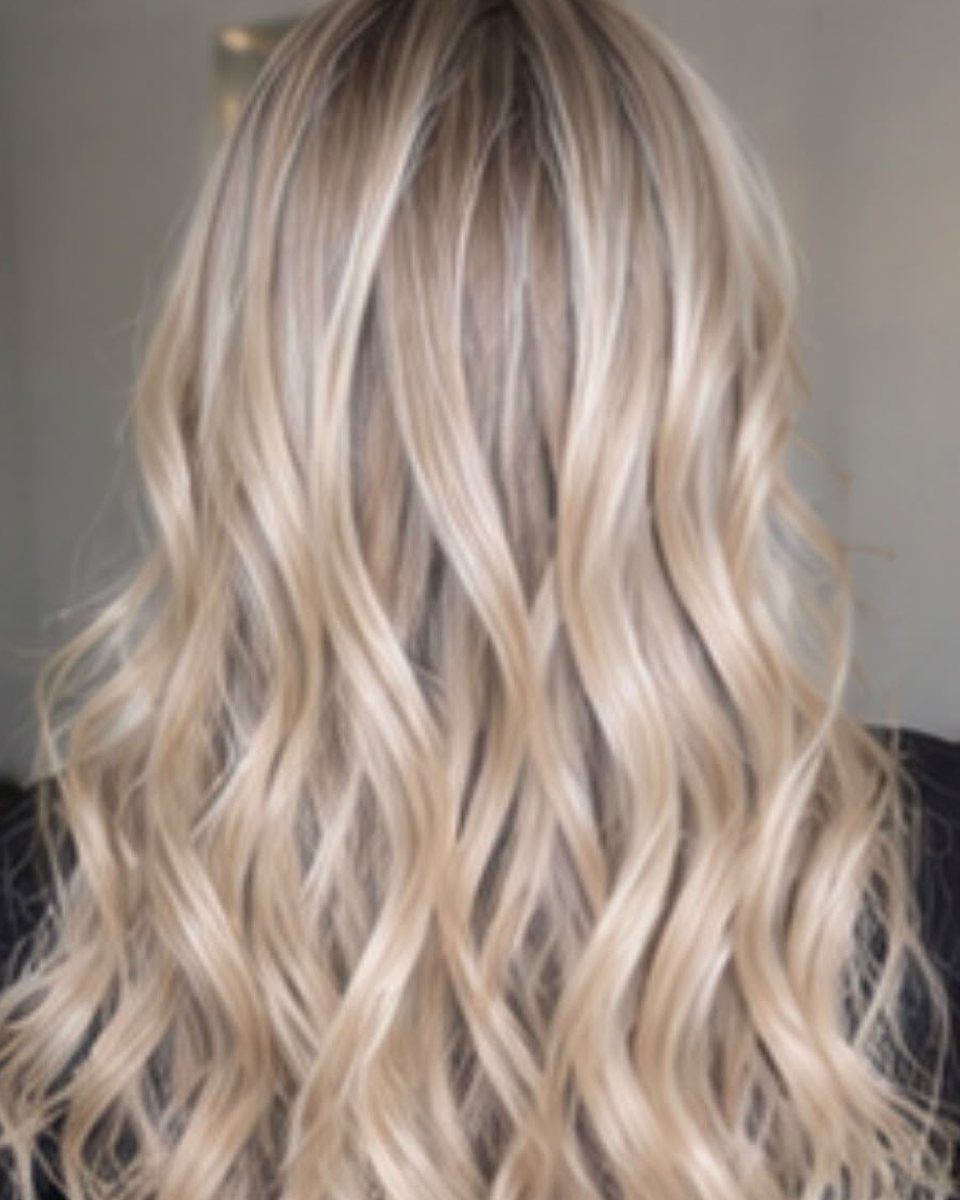 Exemple de mèches blondes lumineuses sur cheveux longs ondulés