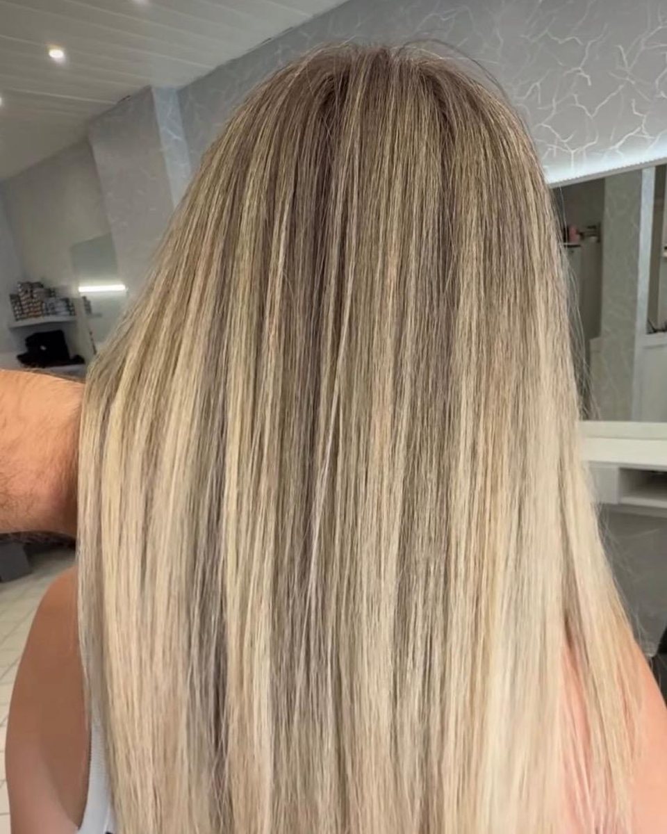 Résultat relief au salon : mèches blondes fines réparties sur cheveux longs lisses, vue de dos